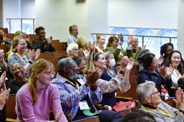 Group of people clapping in a lecture hall