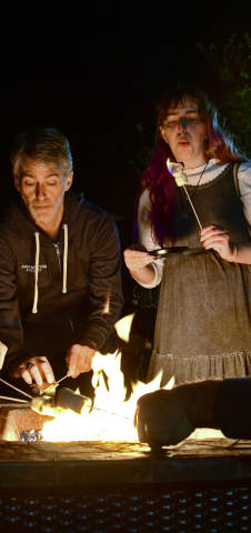 Father and daughter roasting marshmallows over a fire